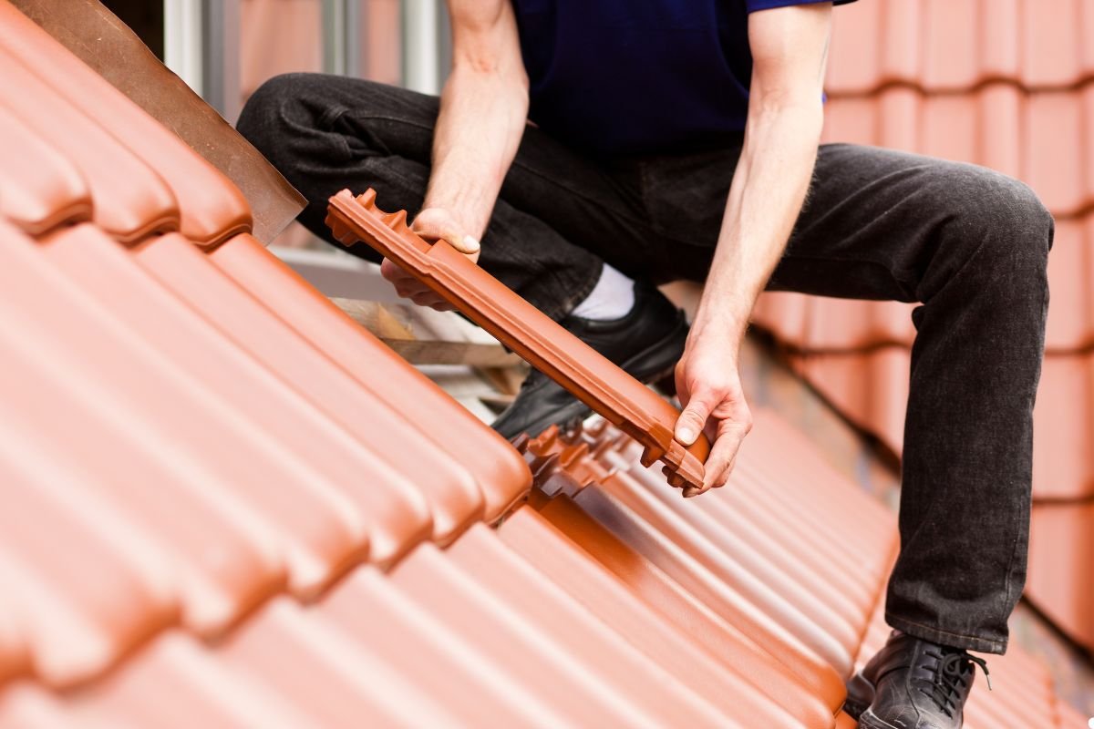 A man on a roof, actively using a tool to perform maintenance work, surrounded by a bright, sunny atmosphere.